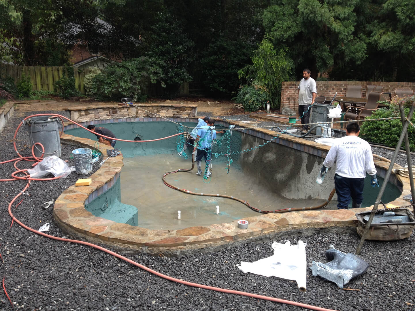 four men working on the construction of a pool