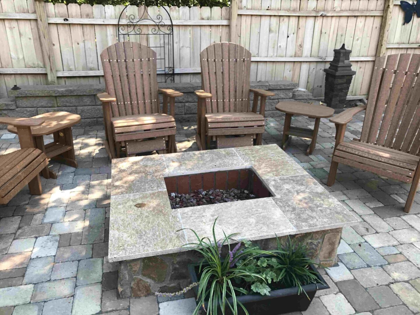 a patio with four chairs and two side tables